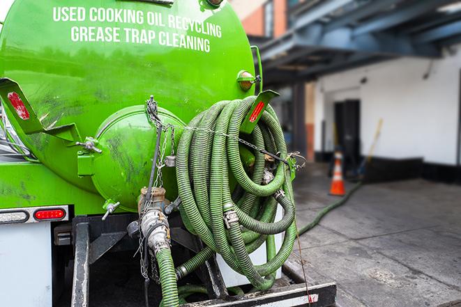 heavy-duty vacuum truck pumping out a grease trap in Bedford